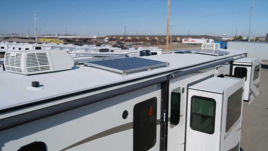 Solar panels mounted on roof of white Montana fifth-wheel trailer