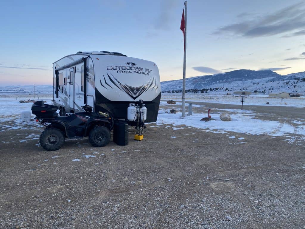 A travel trailer/toy hauler in the snow.