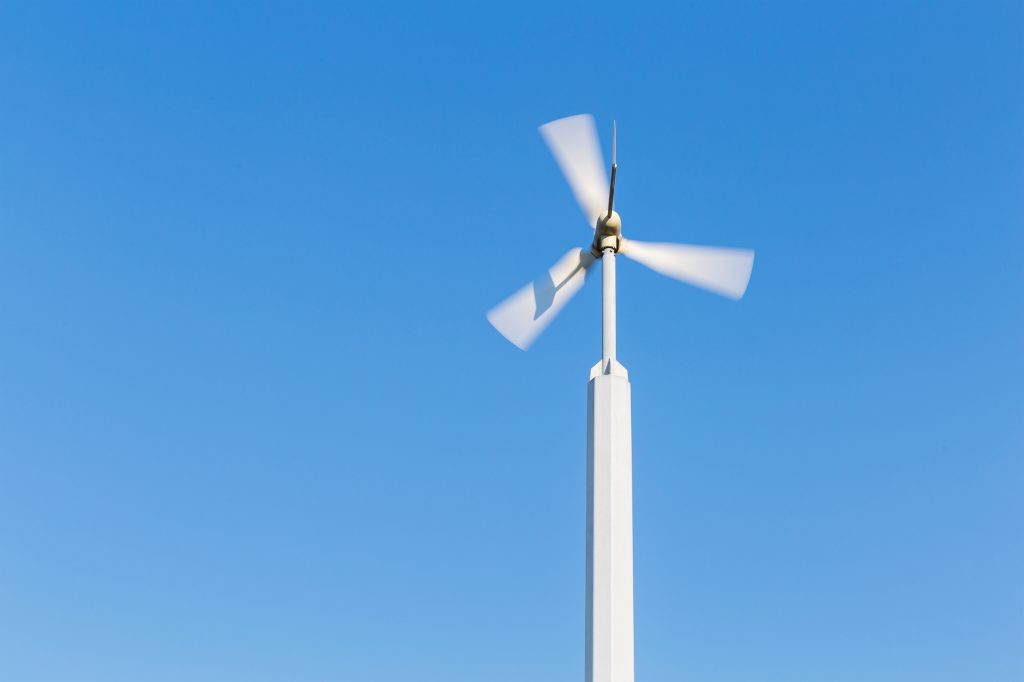 Spinning wind turbine with a blue sky background